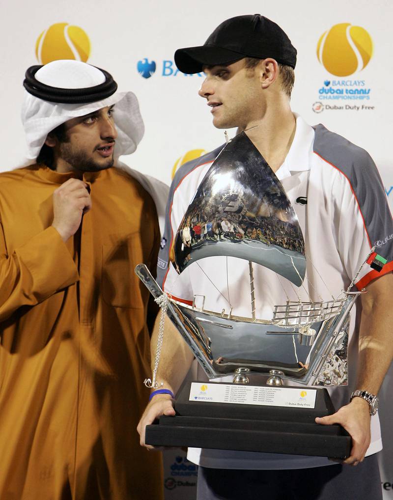 Sheikh Ahmed bin Mohammed bin Rashed al-Maktoum (L) poses with Andy Roddick of the US after his final ATP match against Spain's Feliciano Lopez at the Dubai Tennis championships in the Gulf emirate on March 8, 2008. Roddick produced one of his best performances for many years to win the Dubai Open title with a 6-7 (8/10) 6-4, 6-2 win over Lopez. AFP PHOTO/KARIM SAHIB (Photo by KARIM SAHIB / AFP)