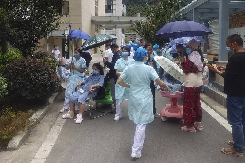 Medical workers move patients to safety at Renmin Hospital, in Yaan city, after the quake struck. Xinhua News Agency/AP