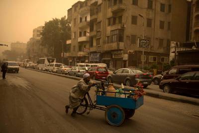 A street vendor pushes his cart during a sandstorm in Cairo, Egypt. Several zoos and parks closed their doors on the same day due to the sandstorm. According to meteorologists, rain is expected later on the same night.  EPA