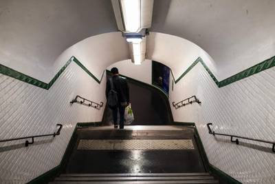 A solitary traveler walks down a staircase in an underground metro railway station in Paris. Bloomberg