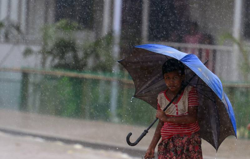 A Rohingya refugee makes her way back home after collecting relief aid during a rain storm at Balukhali refugee camp in Ukhia on July 21, 2018. Myanmar's military engaged in "extensive and systematic" preparations for a bloody crackdown on Rohingya Muslims, a rights group said July 19, in a damning new report that it says justifies a genocide investigation.   / AFP / MUNIR UZ ZAMAN
