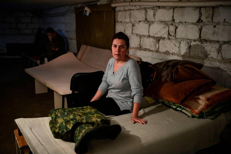 Rita Khachatryan, 50, whose husband and son were sent to the front line, sits in a basement shelter in the city of Stepanakert. AFP