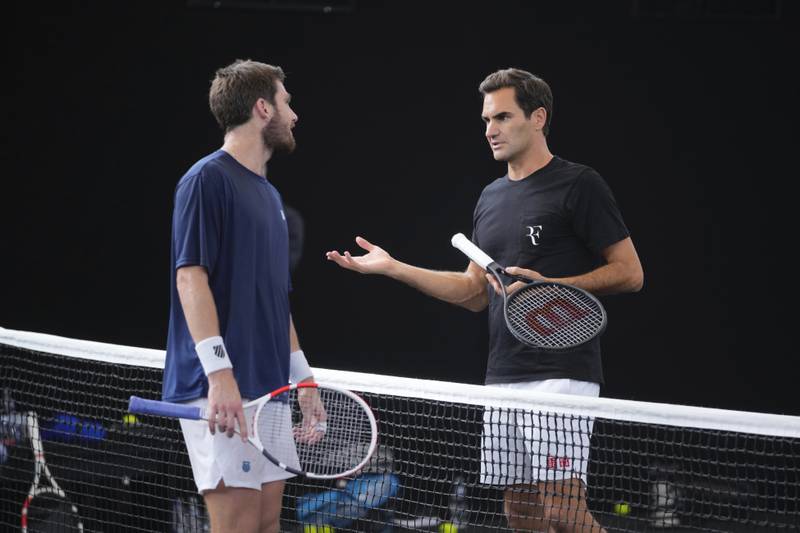 Roger Federer chats with Cameron Norris of Great Britain during a training session in London. AP