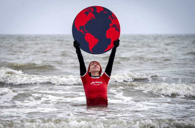 Susie Gray from the Edinburgh Science Festival team stands in the Firth of Forth at Portobello, Edinburgh, holding a giant black and red Earth to highlight the climate emergency and rising sea levels. PA Photo