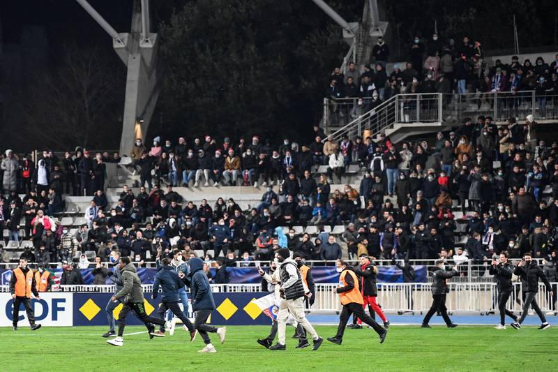 Supporters run on the pitch at half-time during the French Cup round of 64 match between Paris FC and Olympique Lyonnais at the Charlety Stadium. AFP