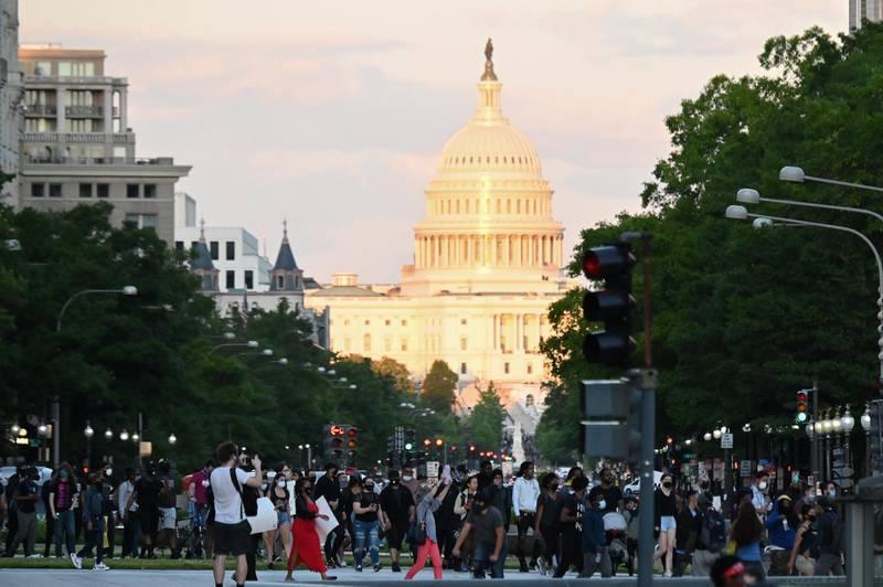 People march towards the White House, with the Capitol building in the background. Reuters