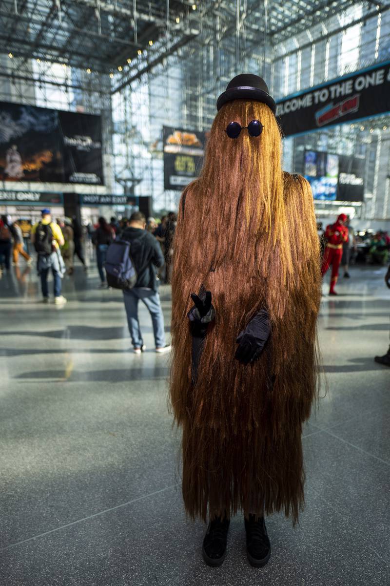 An attendee dressed as Cousin Itt from 'The Addams Family' poses during New York Comic Con. Charles Sykes / Invision / AP