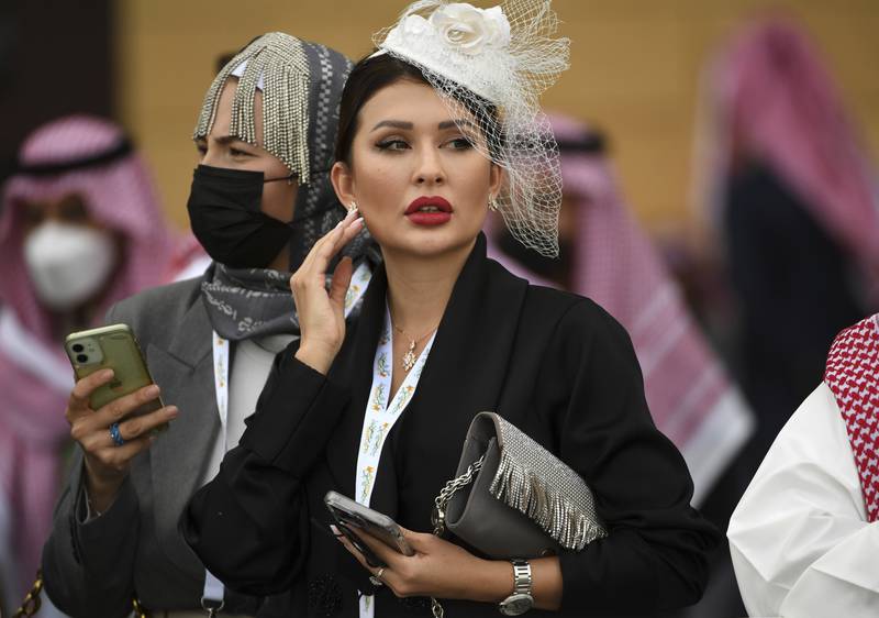 A racegoer watches horses in the parade ring. AP