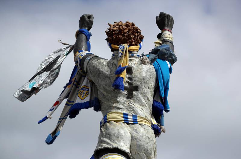 A statue of Billy Bremner is seen covered in scarves outside the stadium before the match. Reuters