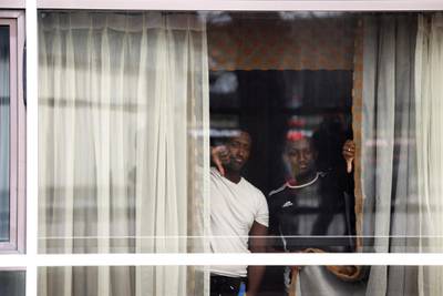 People gesture from a window at the Radisson Blu Hotel. Reuters