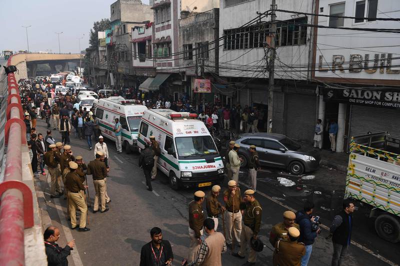 Police personnel and ambulances are seen  along a road following a factory fire in Anaj Mandi area of New Delhi. At least 43 people have died in a factory fire in India's capital New Delhi.  AFP