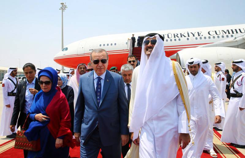 Turkey's President Recep Tayyip Erdogan, centre, accompanied by his wife Emine, left, is greeted by Emir of Qatar Sheikh Tamim bin Hamad Al Thani, right, upon his arrival, in Doha, Qatar, Monday, July 24, 2017. Erdogan has arrived in Qatar on the final leg of a Gulf tour aimed at forging a resolution to the diplomatic standoff gripping the Gulf nation and four fellow Arab countries. (Presidency Press Service via AP, Pool)