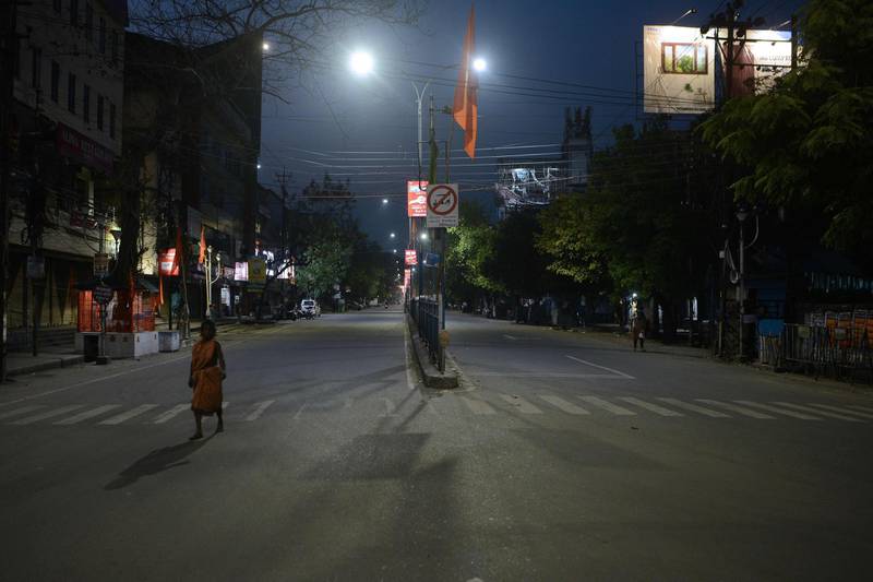 A woman walks along a deserted street during a government-imposed lockdown as a preventive measure against the spread of the COVID-19 coronavirus, in Siliguri on March 24, 2020. / AFP / DIPTENDU DUTTA
