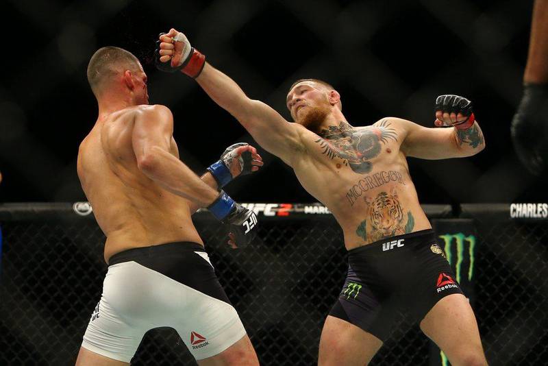 Conor McGregor (R) punches Nate Diaz during UFC 196 at the MGM Grand Garden Arena on March 5, 2016 in Las Vegas, Nevada.   Rey Del Rio/Getty Images/AFP