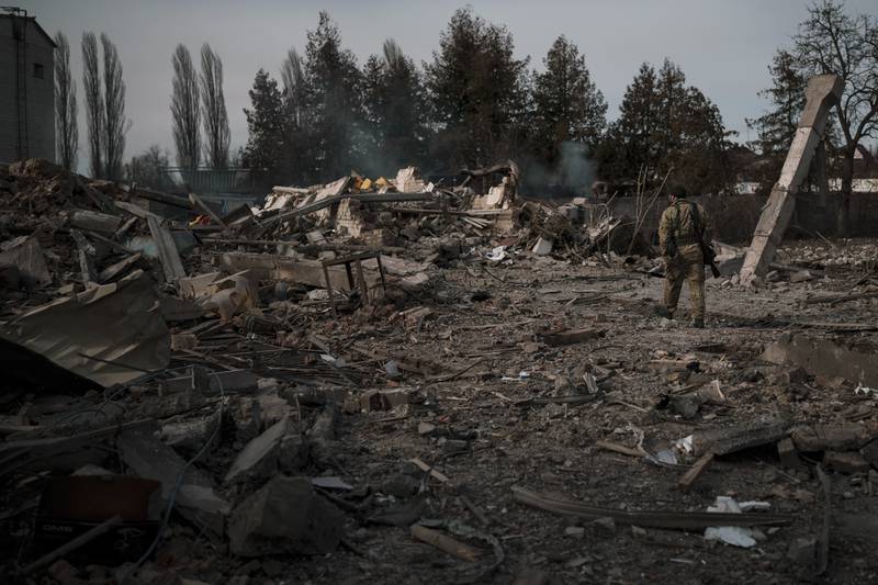 A volunteer of the Ukrainian Territorial Defence Forces walks on the debris of a car wash destroyed by Russian bombing in Baryshivka, east of Kyiv. AP Photo
