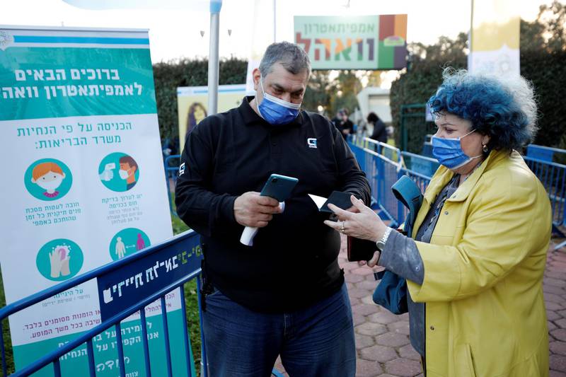 A woman displays her ‘Green Pass’ at the entrance to the Nurit Galron concert at Yarkon Park.