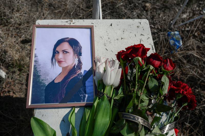 A portrait of a young woman who died during a Russian attack, next to her fresh grave in the  Mykolaiv cemetery. AFP