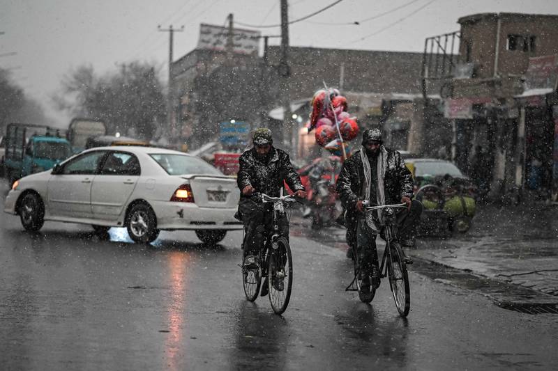 Men cycle along a slippery road.
