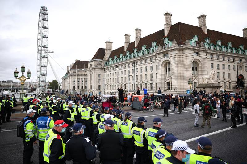 Police officers stand guard as anti-lockdown protesters take part in a march in London. Reuters