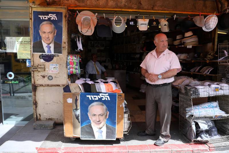 A man stands near posters of Benjamin Netanyahu during his tour at the Mahane Yehuda market. EPA