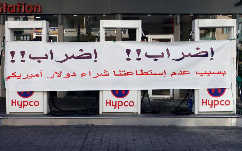 FILE PHOTO: A banner is seen at a petrol station in Beirut, Lebanon November 28, 2019. The banner reads: "Strike!! Strike!! Because we can't buy the U.S. dollar". REUTERS/Mohamed Azakir/File Photo