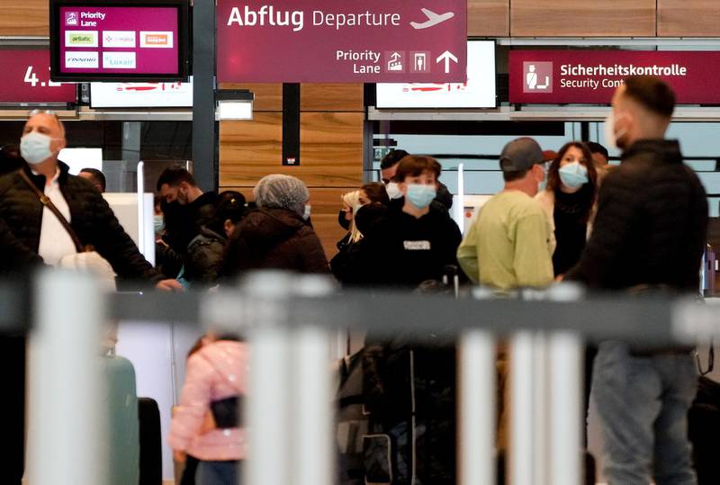 Passengers wait in line to check-in for their flight at Berlin Brandenburg Airport. German tourist are set to travel to Mallorca over the Easter holiday season after the destination was taken off Germany's list of coronavirus 'risk areas.'  EPA