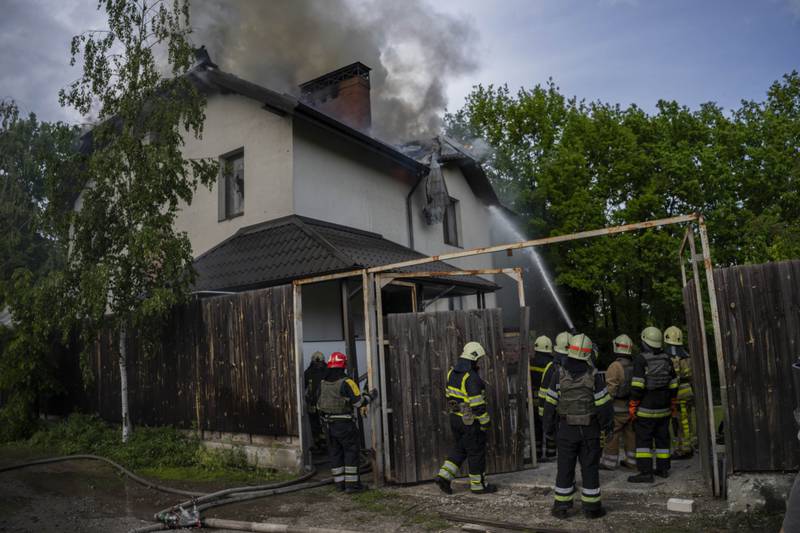 Ukrainian firefighters try to extinguish a fire at a house that was hit by Russian strikes, in Kharkiv. AP