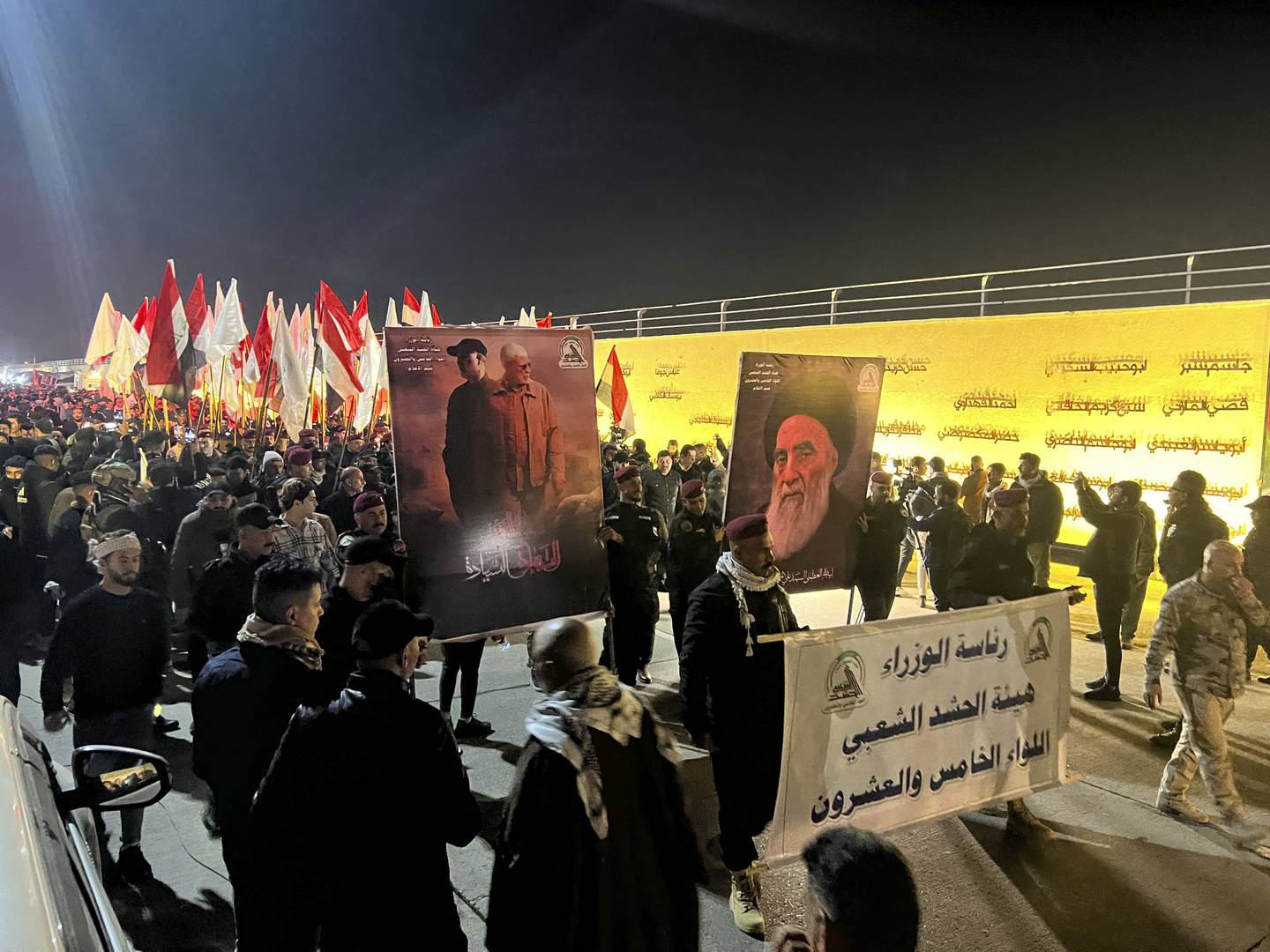 Abu Mahdi al-Muhandis, deputy commander of the People's Mobilization Forces, and people holding a photo of Iranian General Qasem Soleimani in Baghdad.  APs
