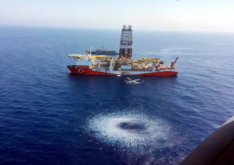 In this Tuesday, July 9, 2019 photo, a helicopter flies over Turkey's drilling ship, 'Fatih' dispatched towards the eastern Mediterranean, near Cyprus. Turkish officials say the drillships Fatih and Yavuz will drill for gas, which has prompted protests from Cyprus. (Turkish Defence Ministry via AP, Pool)
