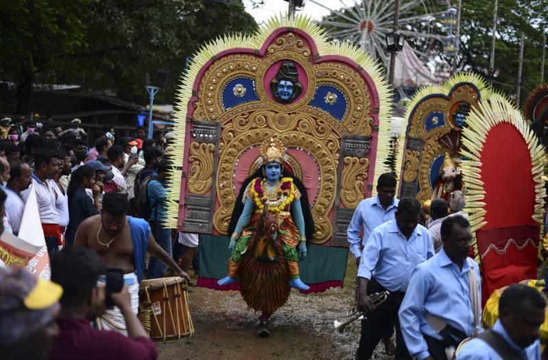 Artists dressed up like Hindu deities participate in the Athachamayam procession in Kochi. AP