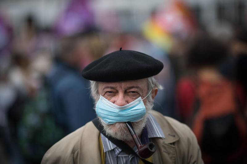 A man smokes a pipe while wearing a face mask in Nantes, western France. AFP