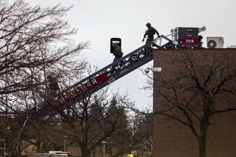 SWAT teams descend from the roof on a fire ladder after a gunman opened fire at a King Sooper's grocery store. AFP