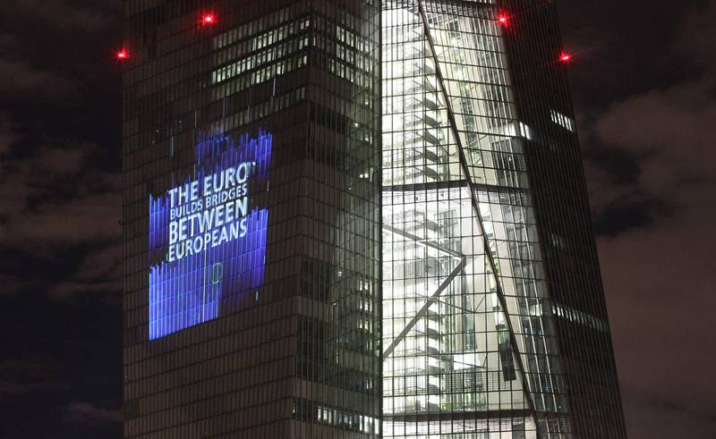 The European Central Bank building illuminated with a sign to celebrate the 20th anniversary of the euro as a cash currency. AFP