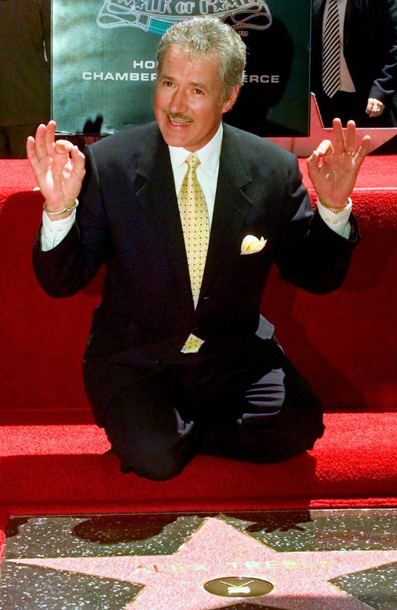 Emmy Award-winning game show host Alex Trebek celebrates his newly dedicated star on the Hollywood Walk of Fame in Los Angeles, on May 17, 1999. AP Photo