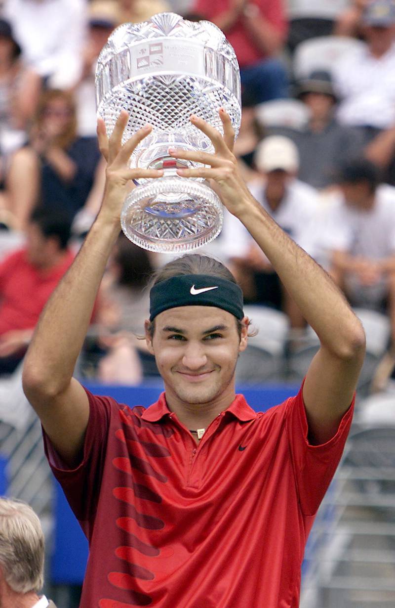 Roger Federer of Switzerland holds the winners trophy aloft after winning the men's final at the at the Sydney International tennis tournament 12 January 2002. Federer beat Juan Ignacio Chela of Argentina in straight sets 6-3,6-3.  AFP PHOTO/David HANCOCK. (Photo by DAVID HANCOCK / AFP)