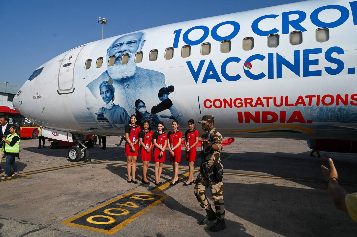 Airline stewardesses pose for a photo during the unveiling of a special liveried SpiceJet Boeing 737, to celebrate India administering its billionth Covid-19 vaccine. AFP