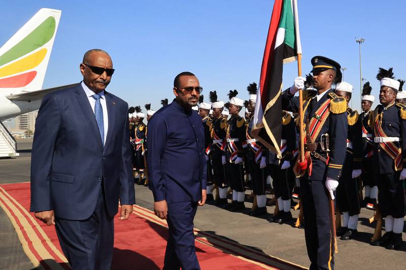 Abiy Ahmed, right, alongside Gen Abdel Fattah Al Burhan at Khartoum Airport during a welcome ceremony. AFP