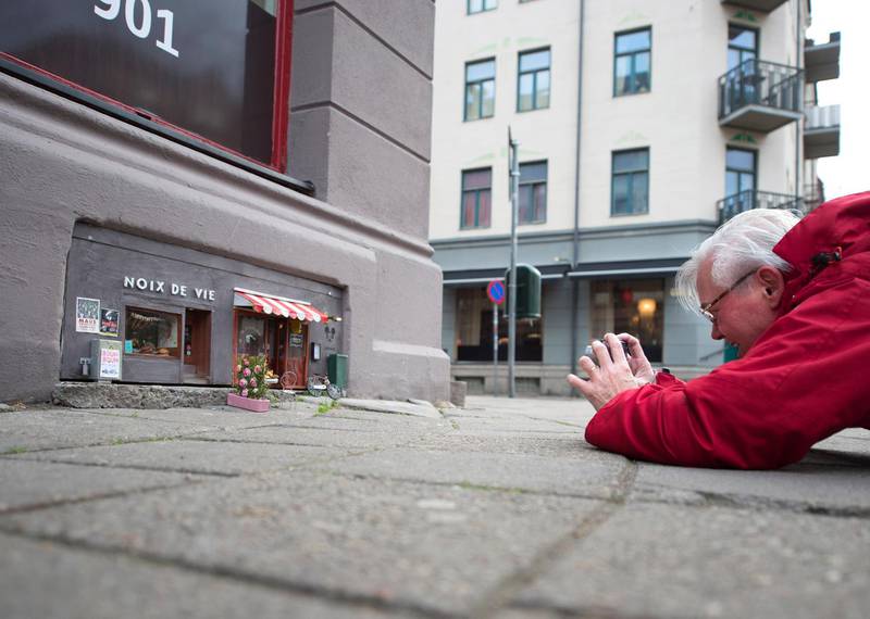 An unknown artist calling himself ”Anonymouse” takes pictures of a mini restaurant and deli-shop for mice he has created in central Malmo, Sweden, on December 9, 2016. (Photo by Bjorn Lindgren / TT News Agency / AFP) / Sweden OUT / RESTRICTED TO EDITORIAL USE - MANDATORY MENTION OF THE ARTIST UPON PUBLICATION - TO ILLUSTRATE THE EVENT AS SPECIFIED IN THE CAPTION