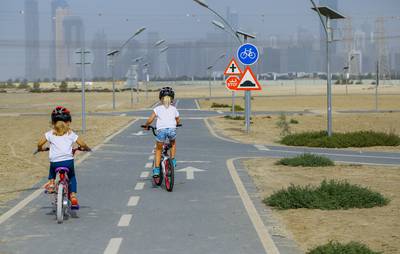 Dubai, UAE.  January 9, 2015.--Al Meydan Cycling Track for kids-- Issy Ralph,7, with her younger sister Phoebe, 5, at the Meydan Cycling Track for kids located right behind the Main Grand Stand of the old camel tracks at the Nad Al Sheba Area.---Victor Besa for The National. *** Local Caption ***  VB-090115-kids cycling-8.jpg
