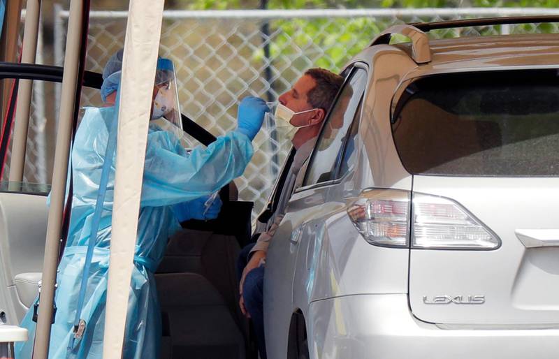 A medical worker tests a person for the coronavirus at a drive-through facility primarily for first responders and medical personnel in San Antonio. AP Photo