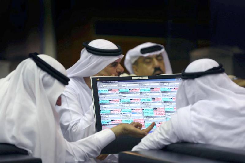 Emirati traders check stock market prices. About 47 per cent of UAE investors intend to increase their allocation to equities in the coming six months, according to a UBS survey. AP