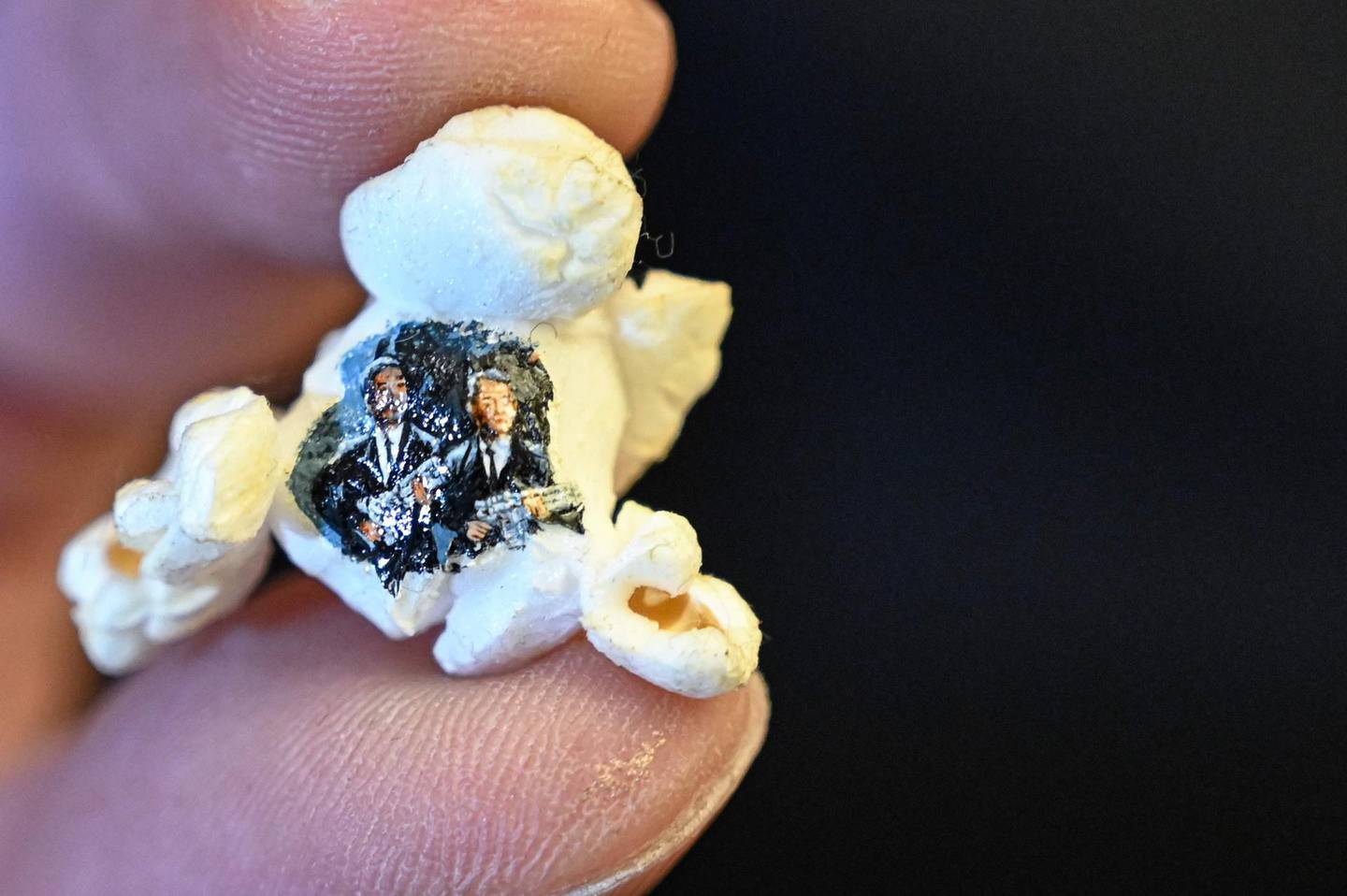 A picture taken on August 23, 2019 shows two armed men in black painted on a popcorn by Turkey's micro artist Hasan Kale in Istanbul.  His canvas could be anything from match sticks, seeds to razors and crown corks. Turkey's micro artist, also known as Turkish Microangelo in reference to Italian Renaissance sculptor and painter Michelangelo, has been hitting his brush onto tiny everyday objects for more than two decades. - RESTRICTED TO EDITORIAL USE - MANDATORY MENTION OF THE ARTIST UPON PUBLICATION - TO ILLUSTRATE THE EVENT AS SPECIFIED IN THE CAPTION
 / AFP / Ozan KOSE / RESTRICTED TO EDITORIAL USE - MANDATORY MENTION OF THE ARTIST UPON PUBLICATION - TO ILLUSTRATE THE EVENT AS SPECIFIED IN THE CAPTION
