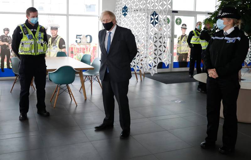 Boris Johnson meets police officers who deal with Covid rule enforcement, during a visit to South Wales Police headquarters in Bridgend, Wales. AP Photo