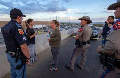 Edie Hallberg, third from left, speaks with police officers outside the Walmart store as she's looking for her missing mother Angie Englisbee, 87, who was in the store during the shooting in El Paso, Texas. AP Photo