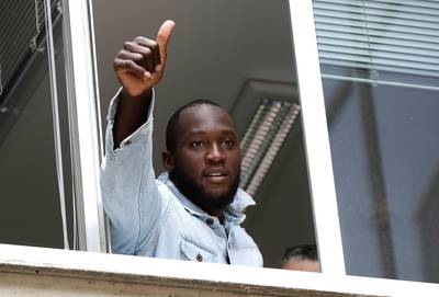 Soccer forward Romelu Lukaku gives his thumbs up as he salutes Inter Milan supporters from a window of the Italian Olympic Committee's headquarters, in Milan,Italy, Thursday, Aug. 8, 2019. Manchester United forward Lukaku is on the verge of completing his move to Inter Milan on the final day of transfers in England. (AP Photo/Luca Bruno)