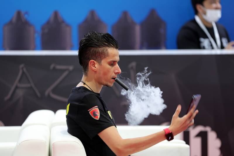 A visitor tries a vape at the exhibition. 