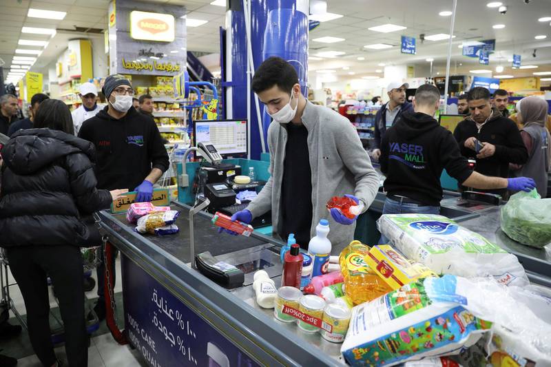 A cashier wearing a face mask and gloves amid concerns over the coronavirus spread works at a mall in Amman, Jordan. Reuters