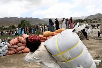 Afghan people wait to receive aid in Gayan. Reuters
