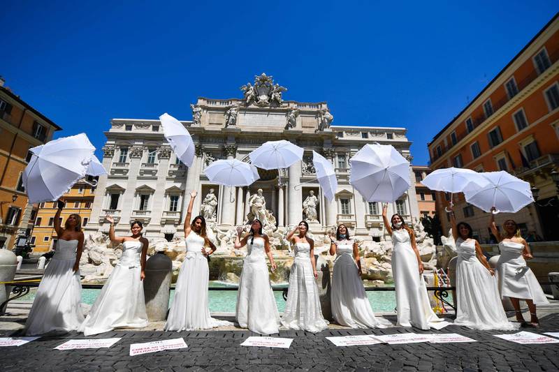 Brides wearing their wedding dress hold a flashmob protest against the postponement of their marriages because of the coronavirus-enforced protocols for all religious ceremonies, by the Trevi fountain in Rome.   AFP