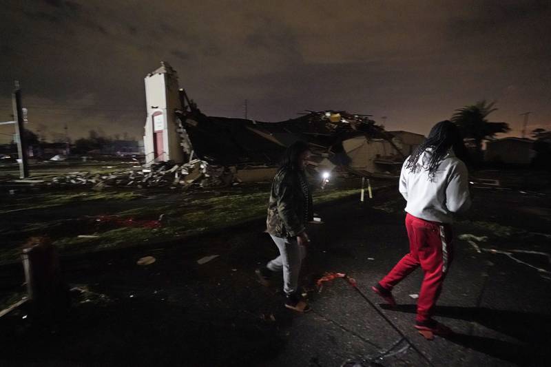 Breign Collins and Darryl Bardell, right, walk past a destroyed church after a tornado struck the area in Arabi, La. , Tuesday, March 22, 2022.  A tornado tore through parts of New Orleans and its suburbs Tuesday night, ripping down power lines and scattering debris in a part of the city that had been heavily damaged by Hurricane Katrina 17 years ago.  (AP Photo / Gerald Herbert)